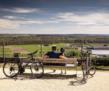 Radtour in Oberelchingen mit Blick auf die Alpen Zwei Radfahrer mit ihren Rädern, die auf einer Bank sitzen und von Oberelchingen auf die Umgebung schauen, mit Blick auf die Alpen.