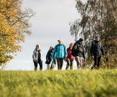 Wandergruppe zwischen Laubbäumen im Herbst