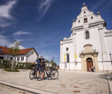 Radtour zur Klosterkirche in Oberelchingen Zwei Radfahrer mit ihren Rädern, die vor der Klosterkirche Oberelchingen stehen.